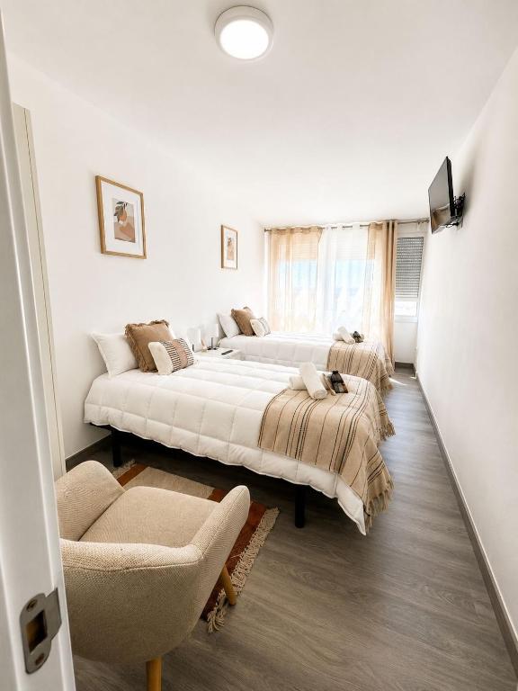 two beds in a bedroom with a couch and a chair at Mirador da Guarda in A Guarda