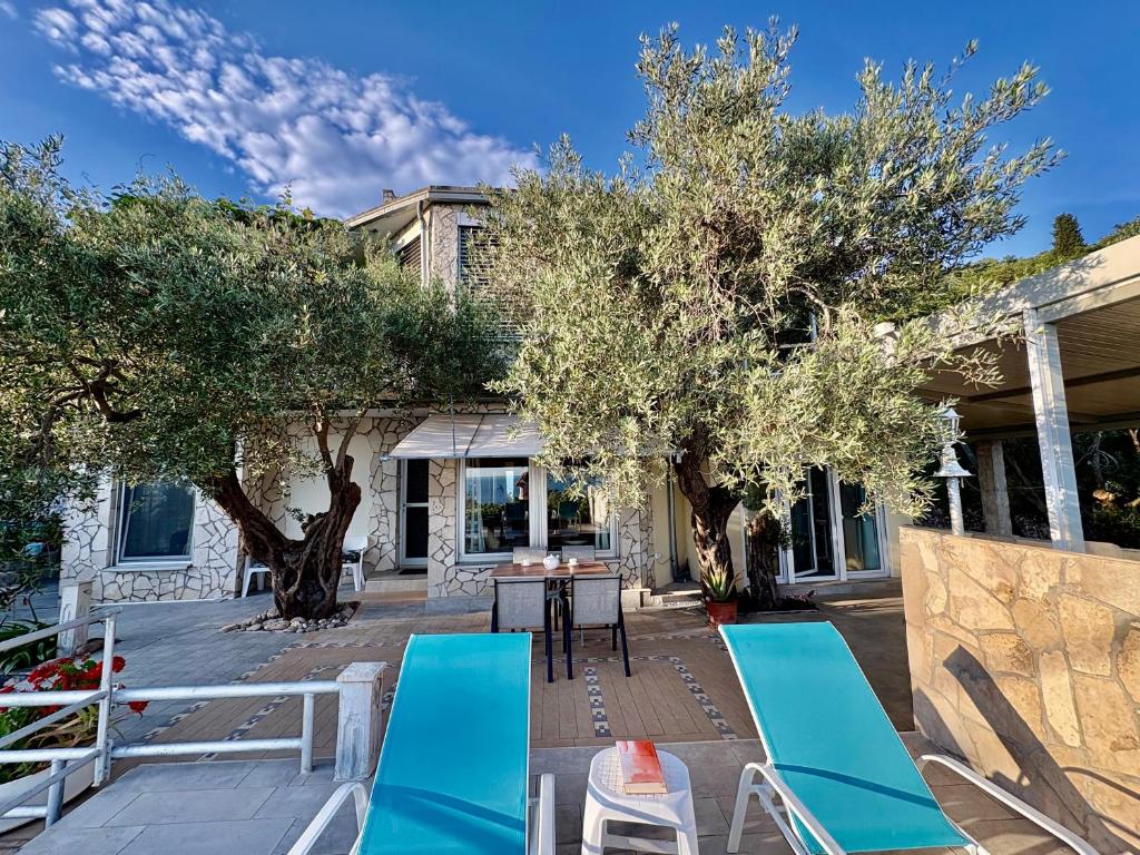 a patio with two chairs and a table and trees at Apartments Mirian in Petrovac na Moru