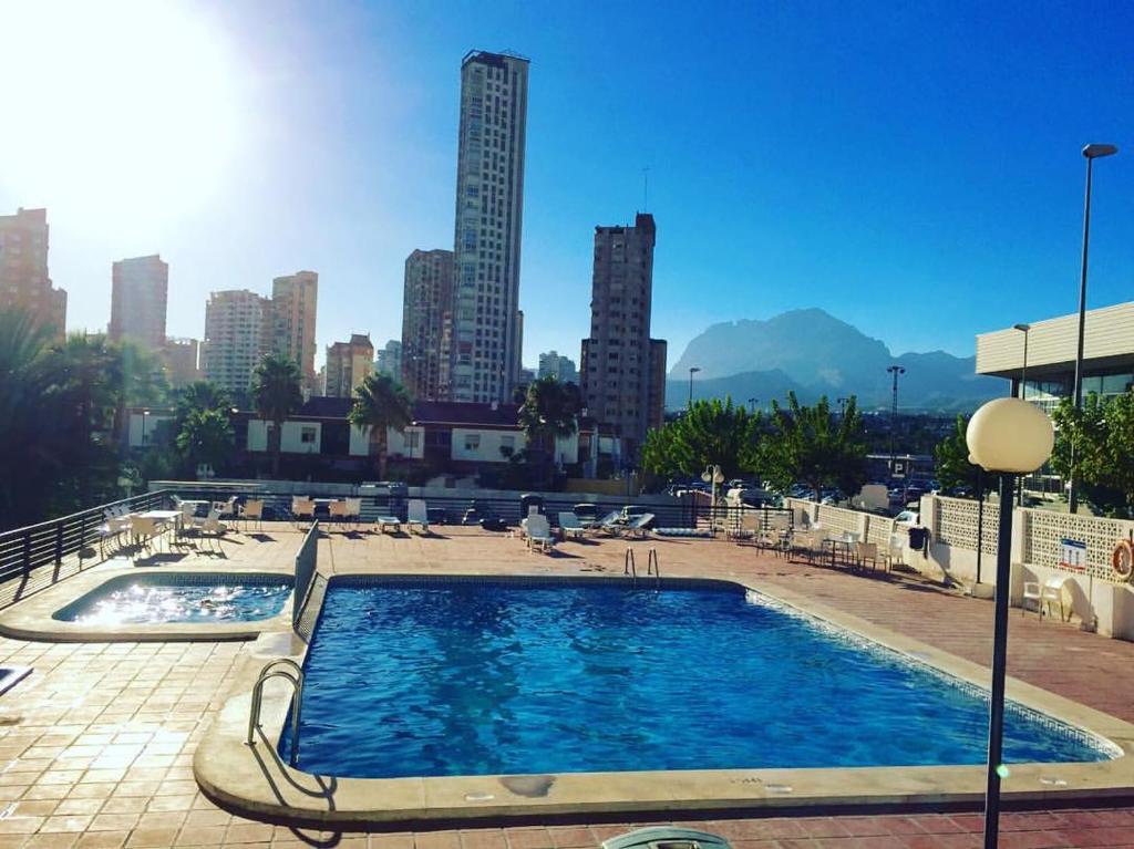 ein großer Pool mit einer Skyline der Stadt im Hintergrund in der Unterkunft Luxmar Apartaments in Benidorm