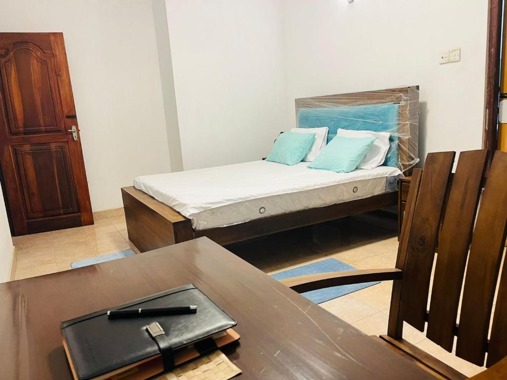 a small room with a bed and a table with a table sidx sidx at Nimro Luxury Residence in Ragama
