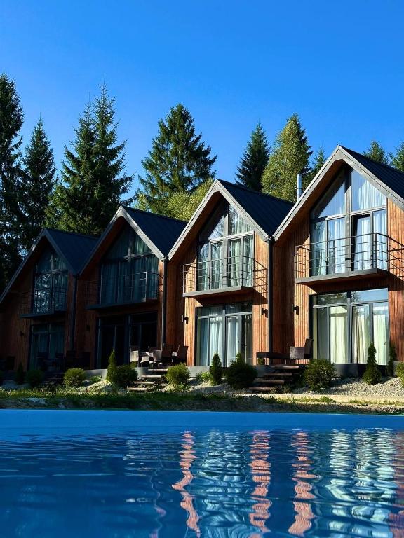 a house on the shore of a body of water at Apex Panorama Hotel in Yablunytsya