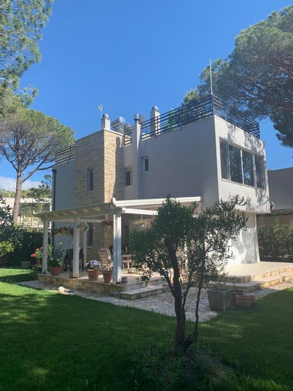 a large white house with a tree in the yard at Vila Eva Lalz in Draç