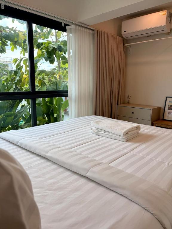a large white bed in a room with a window at 2 Bed & 2 Bath Suite, 2nd floor in Ban Bang Toei (1)