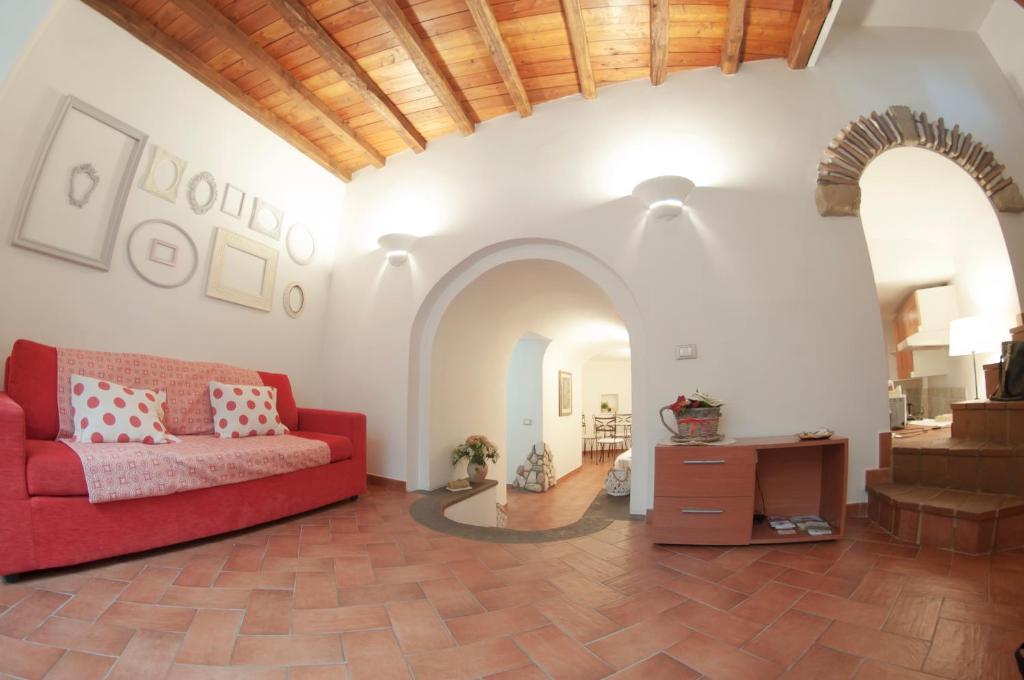 a living room with a red couch and a table at Il Rosciolo Sulla Francigena in Formello