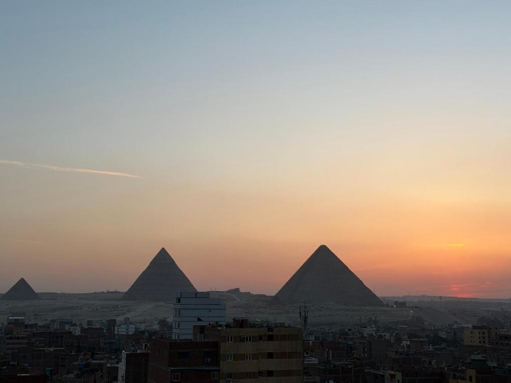 a view of the pyramids of giza at sunset at Pyramids gardens guest House in ‘Ezbet `Abd el-Ḥamîd