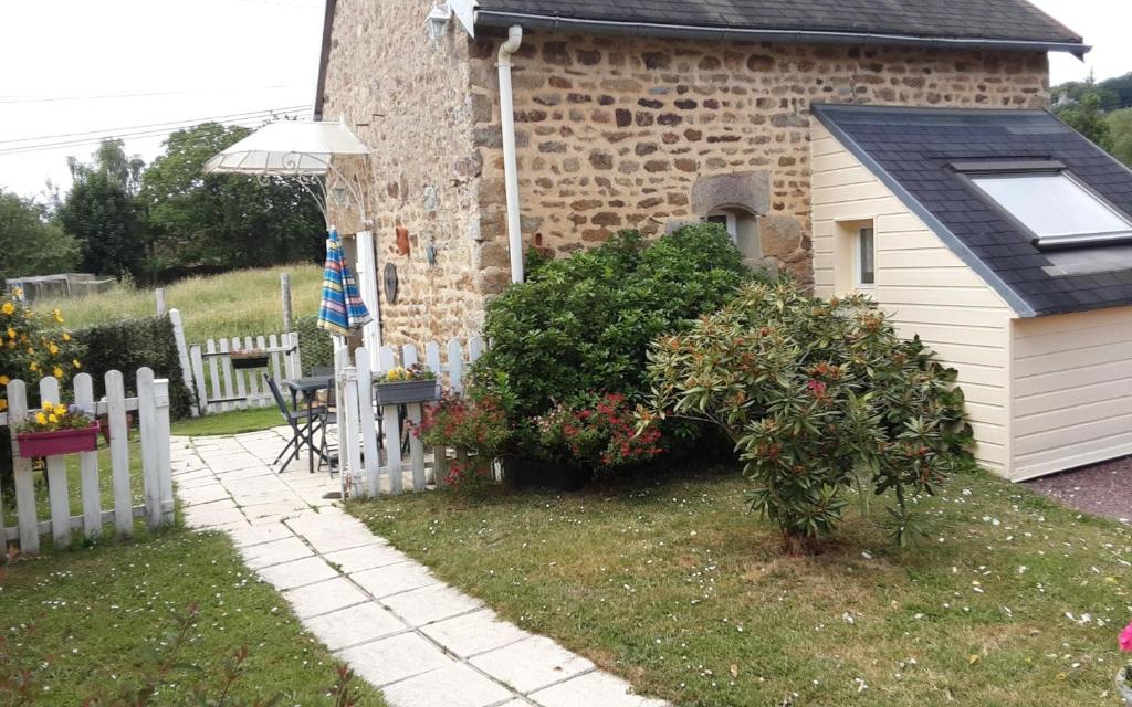 a garden with a white fence and a house at Le Petit Montceaux in Le Val-Saint-Père