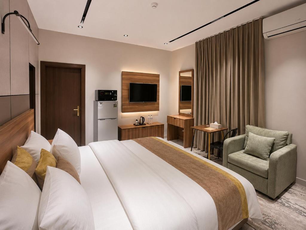 a hotel room with a large bed and a chair at كادي بارك الخليج in Riyadh