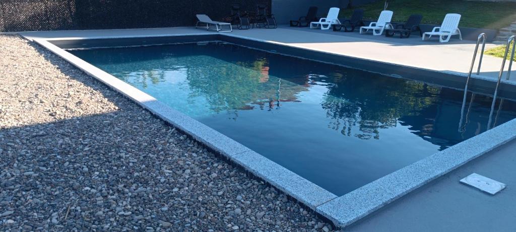 a swimming pool with chairs in a backyard at Vila Ali in Krivoglavci
