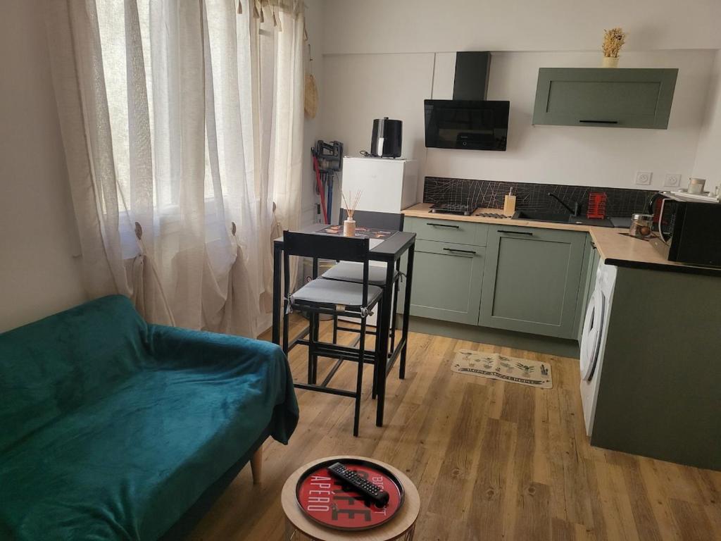 a kitchen with a couch and a table in a room at Elegant studio Hyper center in Rodez