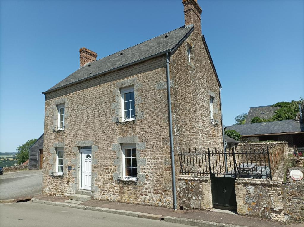 an old brick building on the side of a street at Gite Auvraysien 10p in La Forêt-Auvray