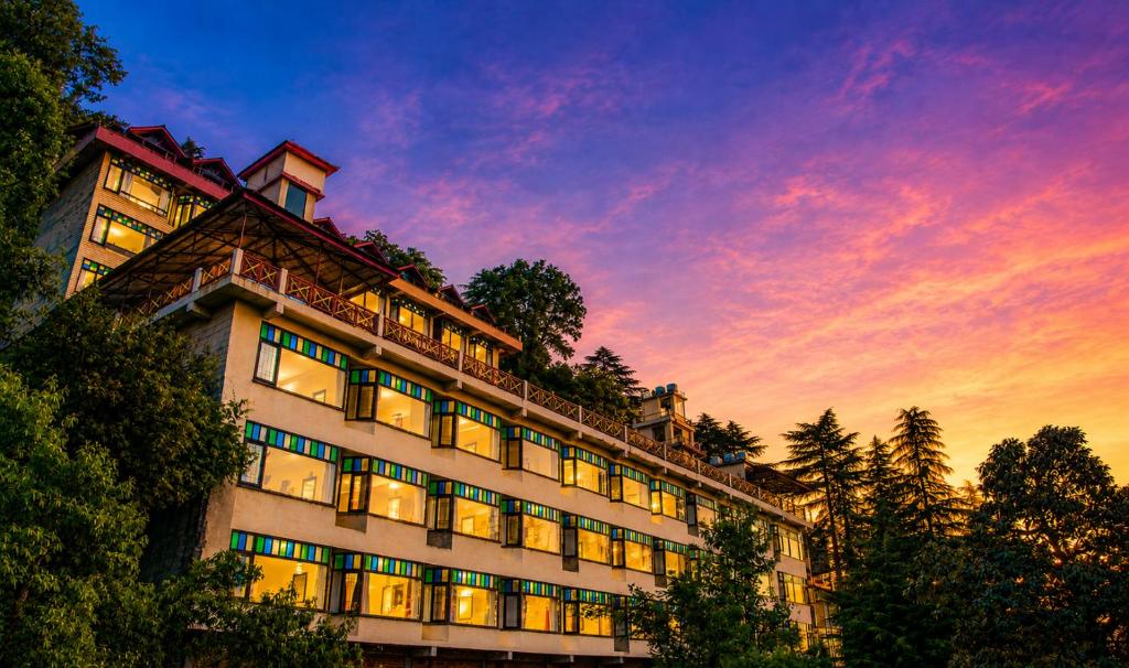 a building with a sunset in the background at Snow Valley Resorts Dalhousie in Dalhousie