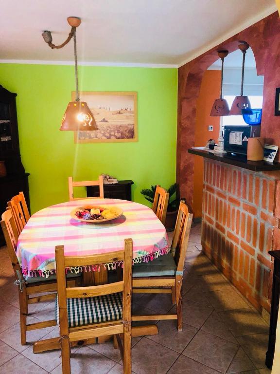 a dining room with a table and a green wall at Sobe- Rooms - Apartments - Free parking! in Maribor