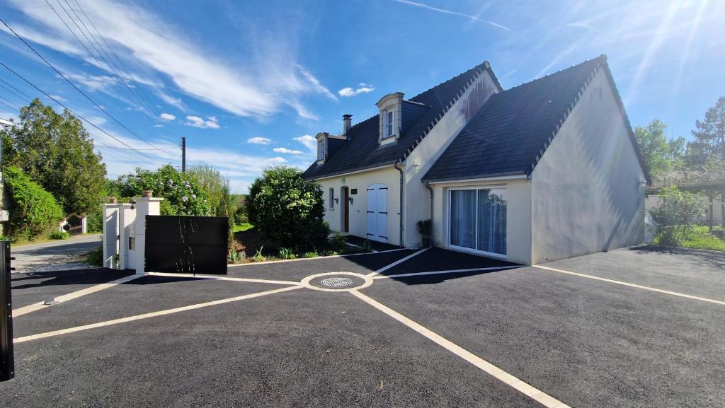 a white house with a parking lot at La Parenthèse by CHERDECOUVERTE in Sambin