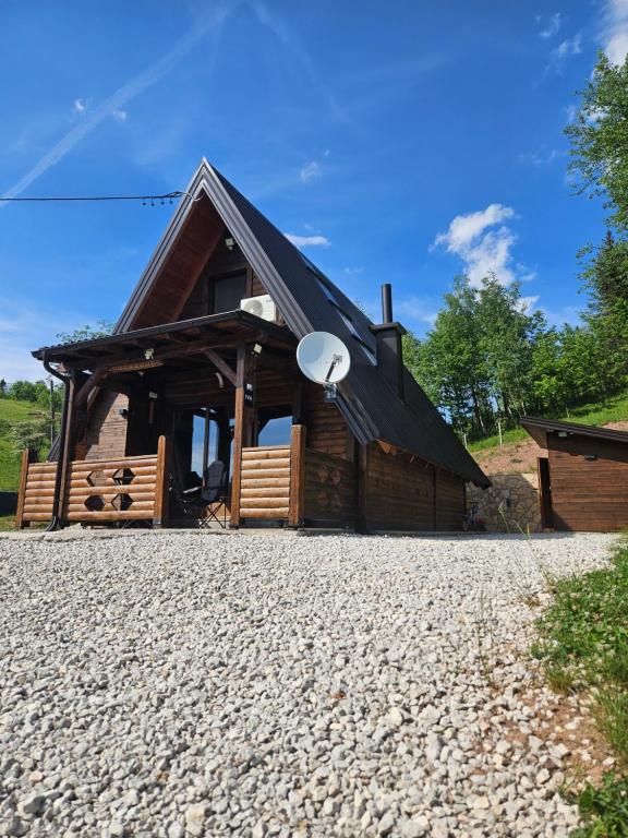 a cabin with a black roof on a gravel driveway at Vikendica IVA in Pale