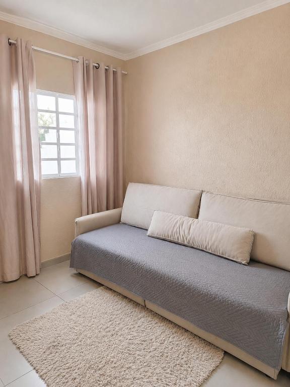 a bed in a room with a window at Ampla, com 5 vagas de carro e bem próxima das empresas da região in São José dos Pinhais