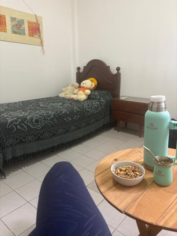 a room with a bed and a table with a bottle of water at Barrio La Victoria in Ezeiza