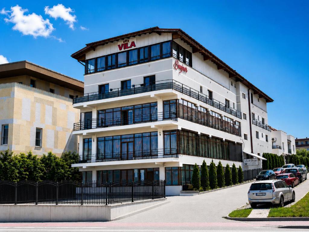 a large building with cars parked in front of it at Apart Hotel Bonjour Cluj in Cluj-Napoca