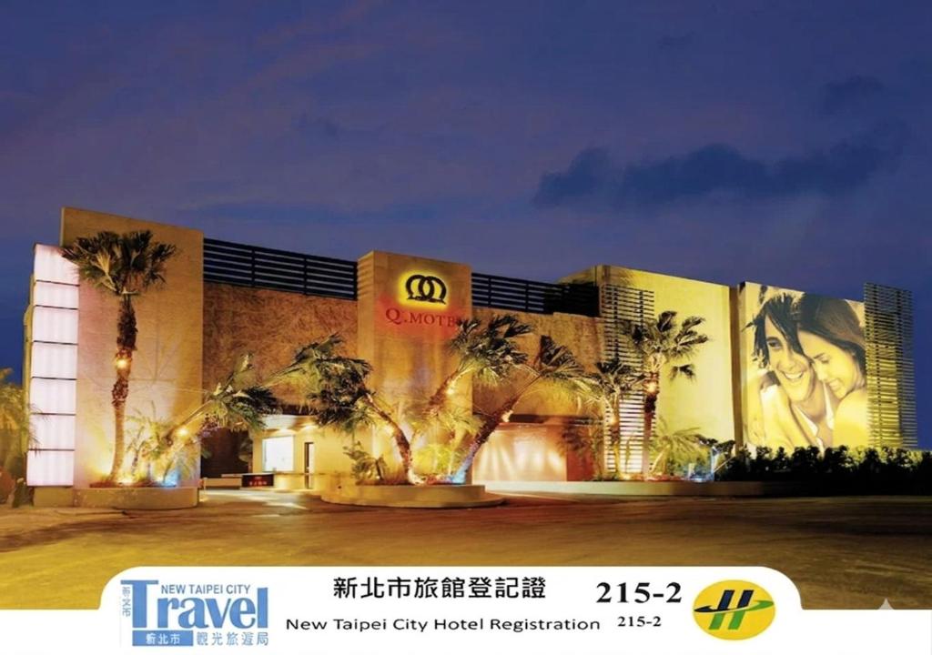 a building with palm trees in front of it at Q Motel精品旅館 in Tucheng
