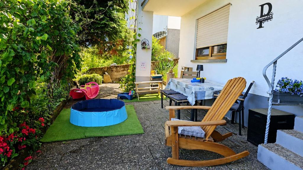 a patio with a table and chairs and flowers at Ferienwohnung Panoramablick Bermersbach in Forbach