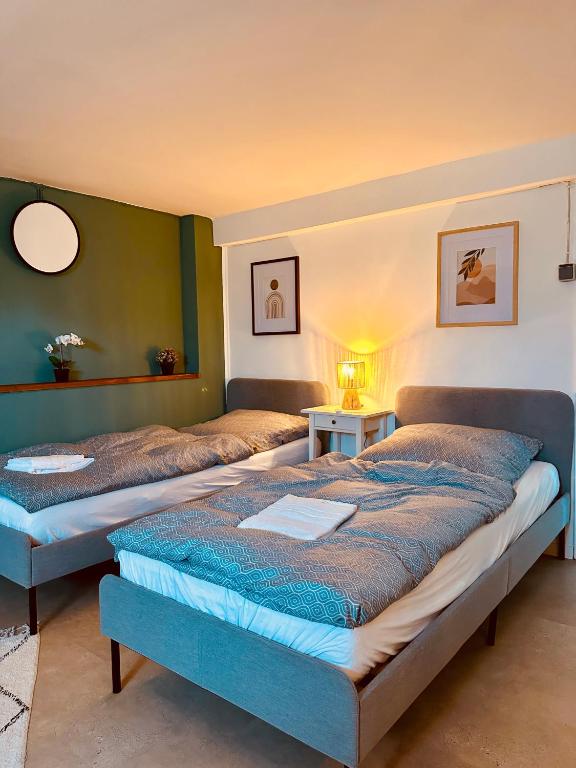 two beds in a room with two tables and a lamp at Cozy Apartment in Bad Oldesloe