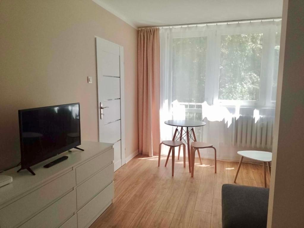 a living room with a television and a table and chairs at Cichy Kącik in Wadowice