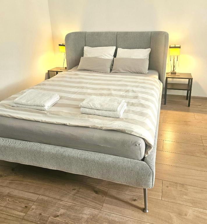 a bed with two towels on it in a bedroom at Rynek Staromiejski Apartment in Koszalin
