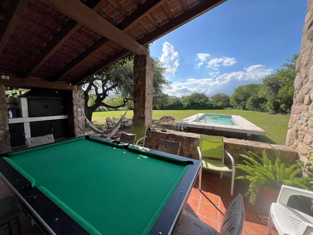 a pool table on a patio next to a swimming pool at Quinta lo de Dito in Villa Allende