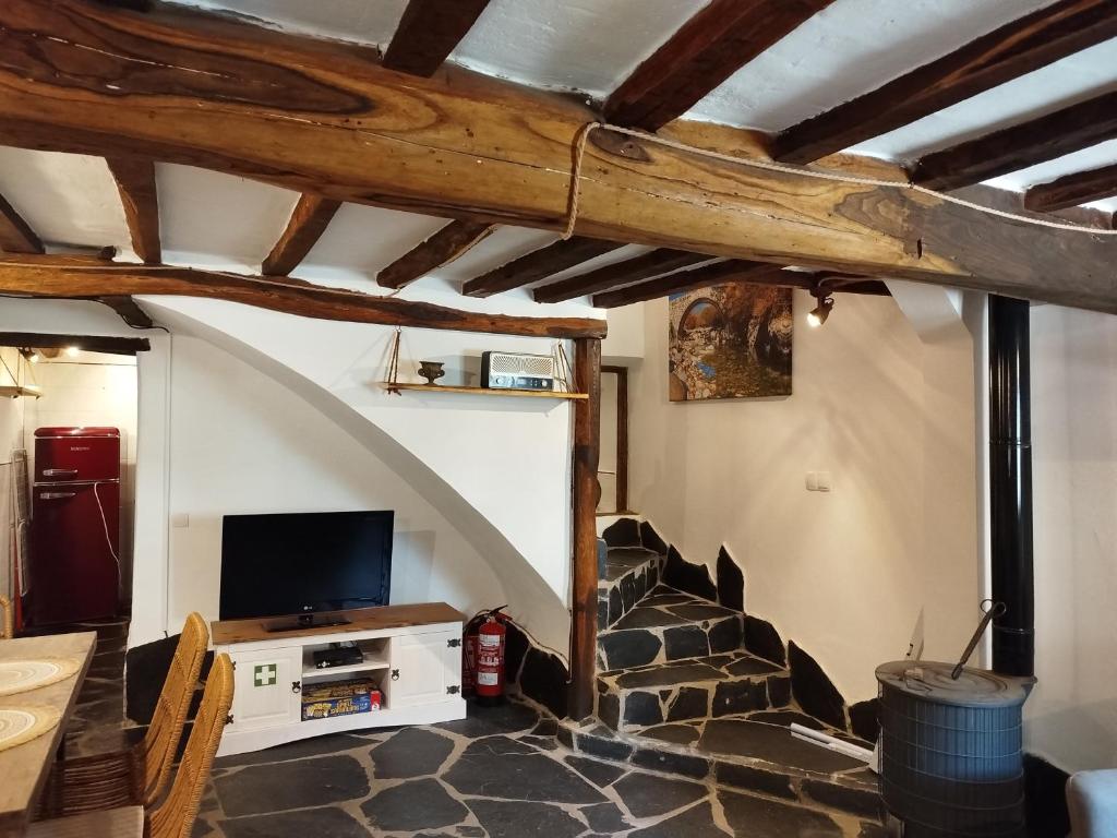 a living room with a stone staircase and a tv at El Silencio in Mesegal