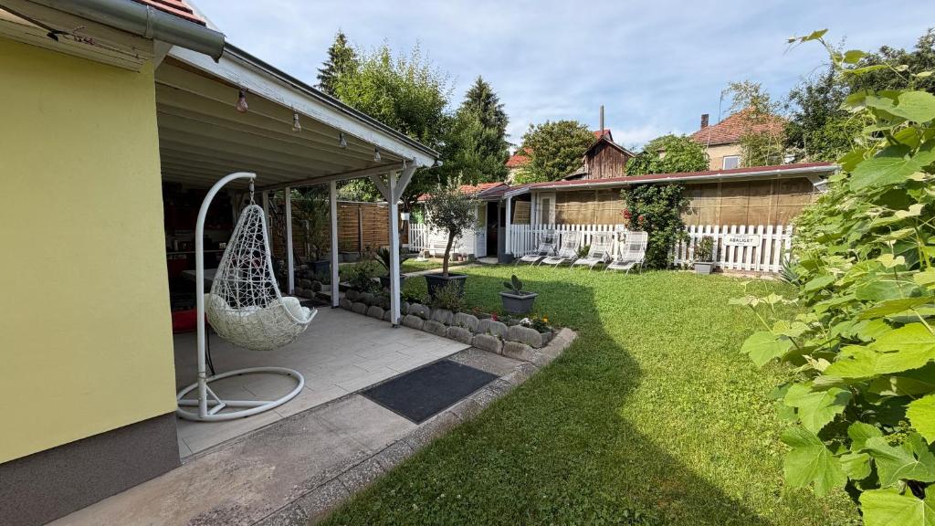a backyard with a yard with a swing at Niki Vendégház in Abaliget
