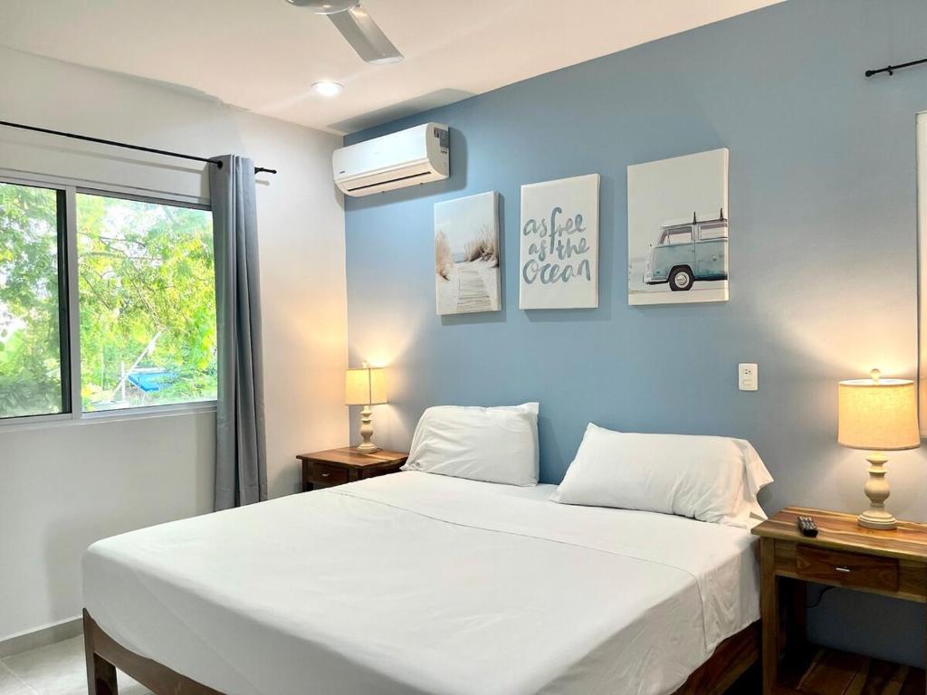 a bedroom with a white bed and a blue wall at Private apartment near the esplanade - KB2 in Campeche