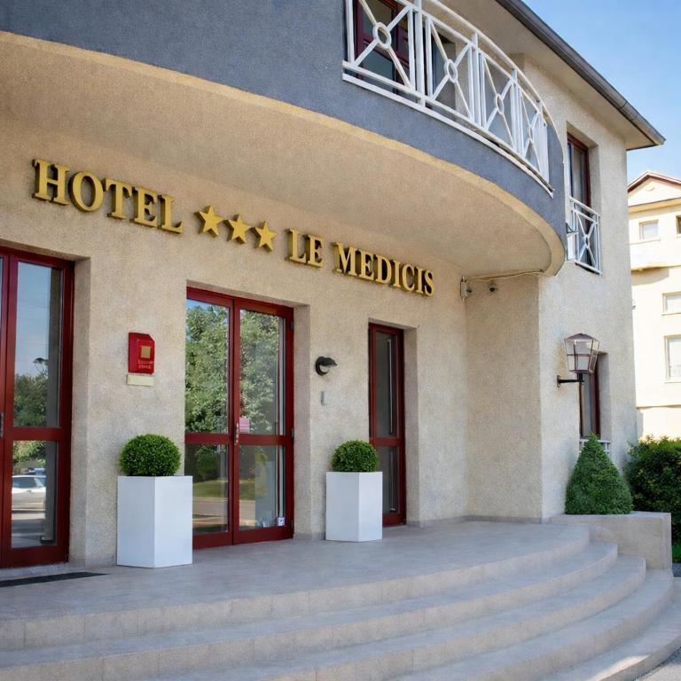 a hotel with a sign on the front of a building at Hotel Médicis in Roussillon en Isere