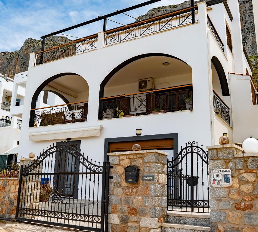 a white building with a gate and a balcony at Casa Sabine in Masouri