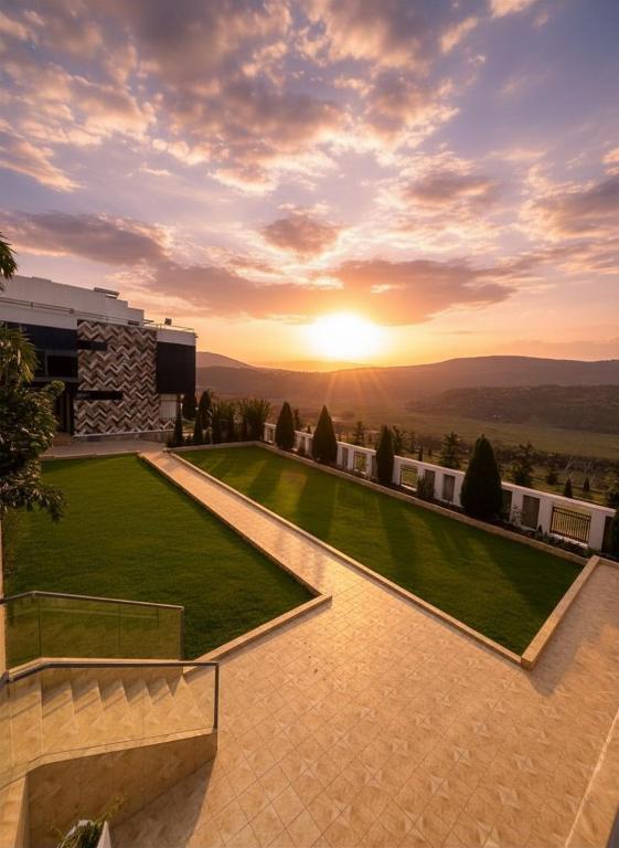 a view of the sunset from a house with a lawn at Plenty Residence by Splendid Hotel, Retreat & Group Stay Near Kigali in Runda