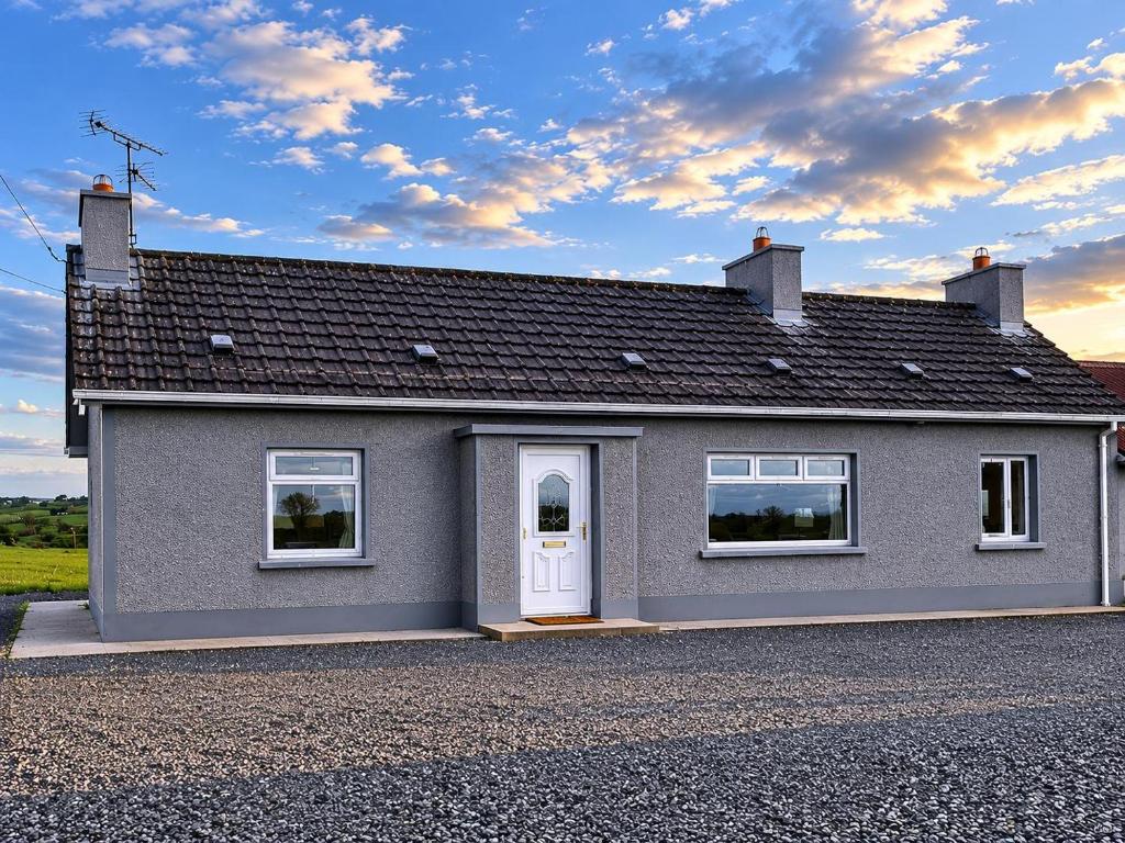 a grey house with a white door on a driveway at Hillview Cottage Eskra in Curr