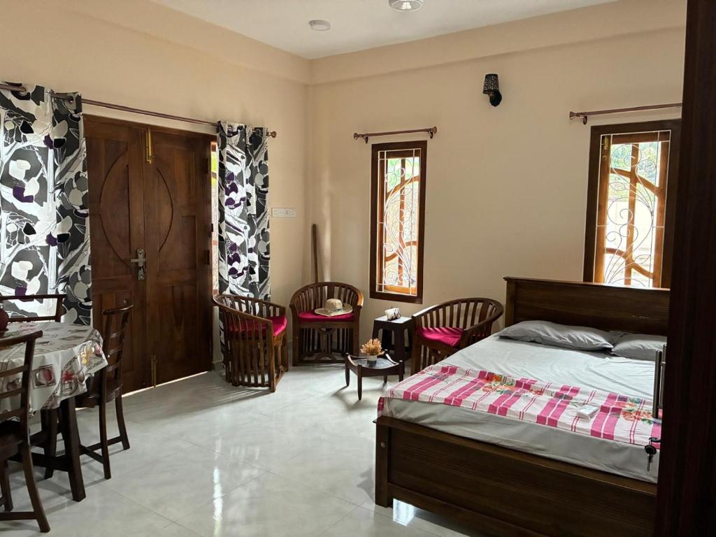a bedroom with a bed and a table and chairs at Velu House - 2-Room Apartment in Jaffna
