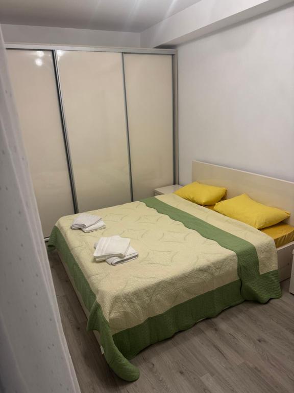 a bedroom with a bed with towels on it at Otopeni Maramures in Otopeni