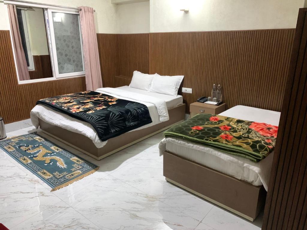 a hotel room with two beds and a window at LHO-Men RESIDENCY in Gangtok