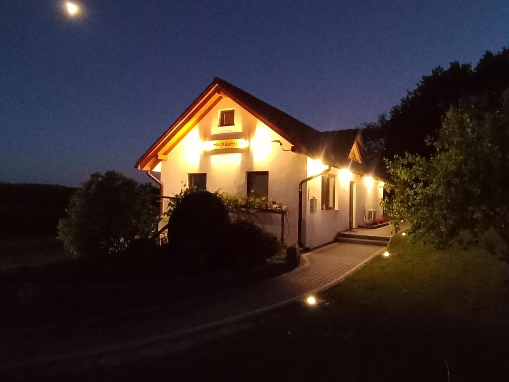 a house with lights on the side of it at night at Gawędówka in Czchów