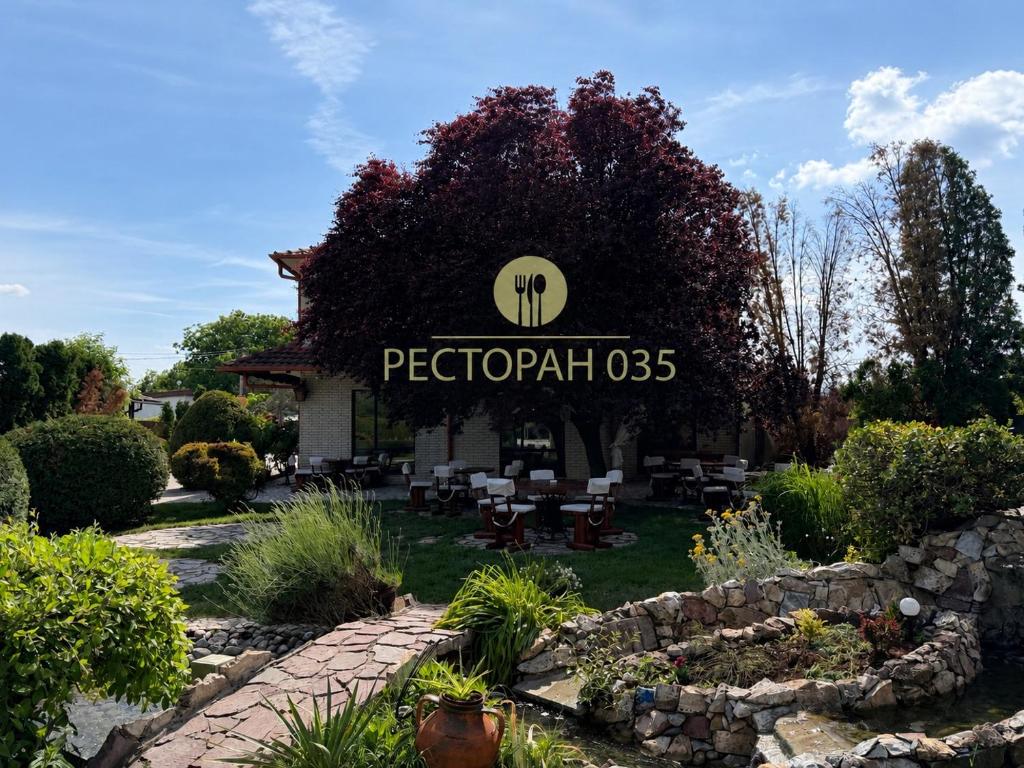 a sign for a restaurant in a garden at Restaurant&Rooms 035 in Paraćin