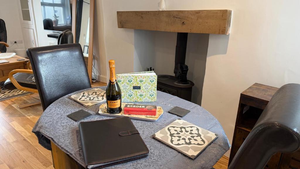 a table with a bottle of wine and a laptop at The Burrow in Kendal