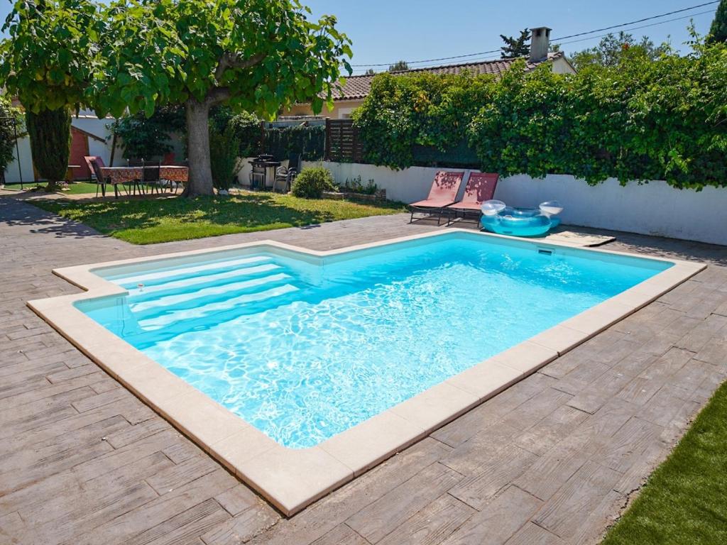 a swimming pool in a yard at Les Elles du Moulin Avec Piscine in Vedène