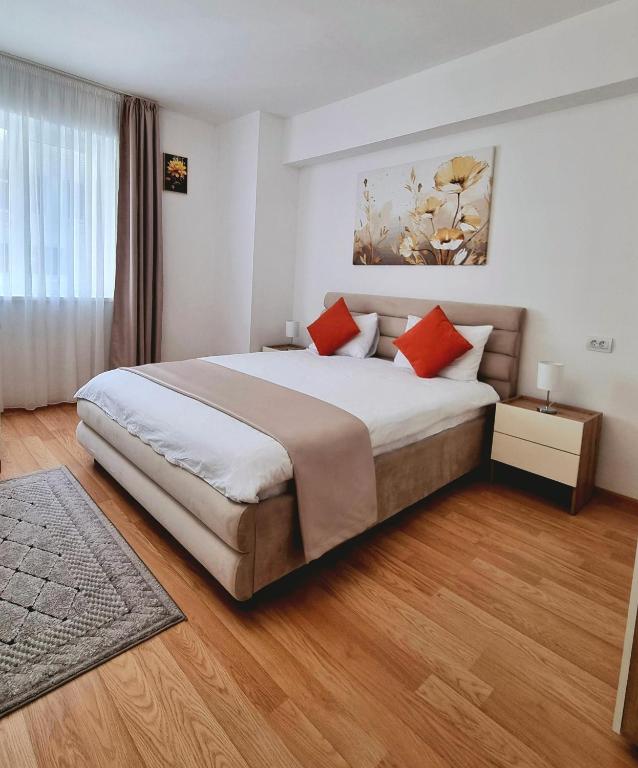a bedroom with a large bed with red pillows at Rin Elegance Apartament in Bucharest