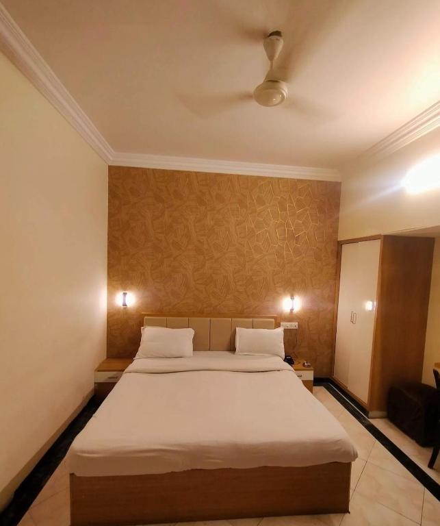 a bedroom with a large bed with white sheets at New Vivaantaa Hotel in Aurangabad