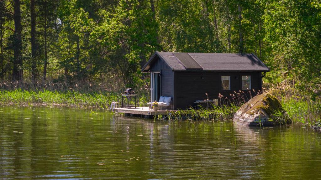 a house on a dock on a body of water at The Floating Lodge in Linköping