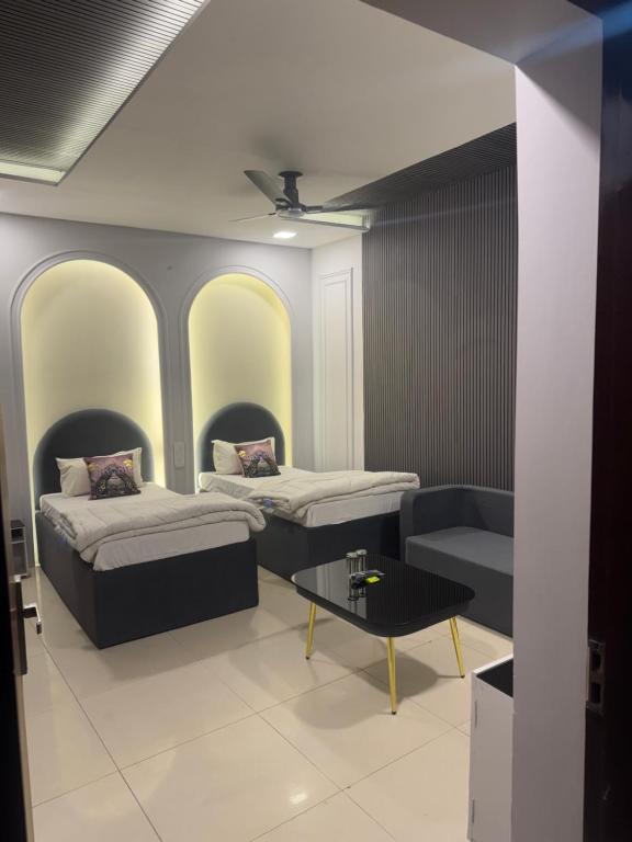 a room with two beds and a coffee table at Hotel American in Sahāranpur
