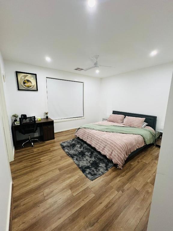 a bedroom with a bed and a white wall at Mickleham Prestige Homestay in Mickleham