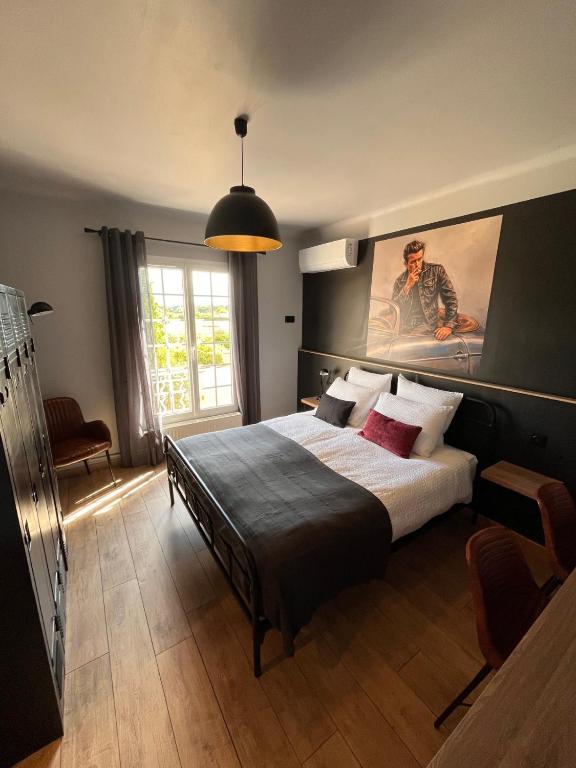 a bedroom with a bed with a painting on the wall at Gîtes et Chambres Atypiques Le Temps des Légendes in Saint-Quentin-la-Poterie
