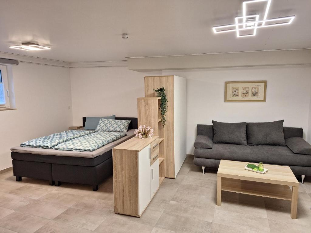a living room with a bed and a couch at Das kleine SOTEL in NuÃŸbaum