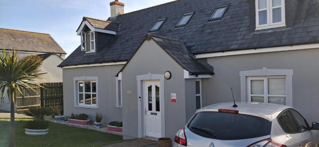 a white house with a car parked in front of it at Sunset Bed and Breakfast in Broad Haven
