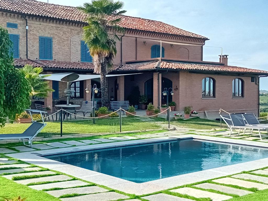 a house with a swimming pool in front of a house at Da Elvira in Costigliole dʼAsti